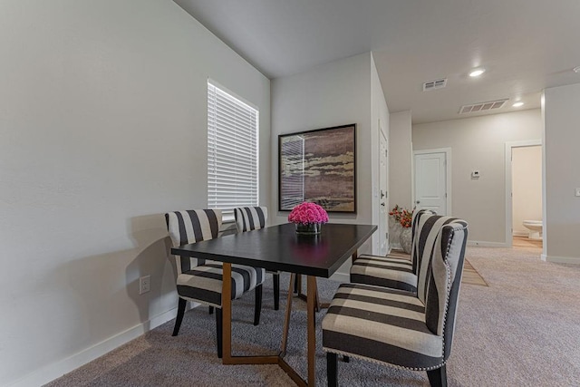 dining room featuring baseboards, light carpet, and visible vents