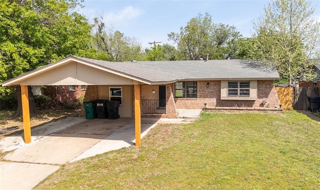 single story home with brick siding, fence, a front lawn, concrete driveway, and an attached carport