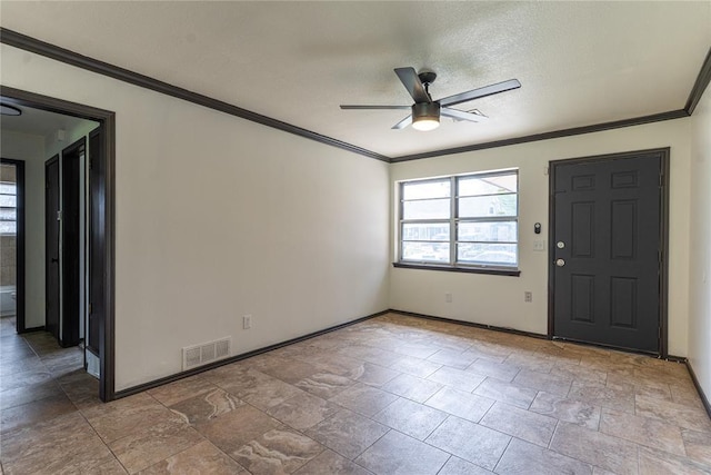 foyer featuring visible vents, crown molding, baseboards, stone finish floor, and a ceiling fan