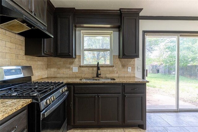 kitchen featuring a sink, stainless steel range with gas stovetop, plenty of natural light, tasteful backsplash, and under cabinet range hood