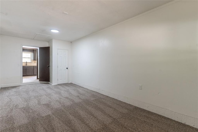 empty room with recessed lighting, baseboards, light carpet, and a sink