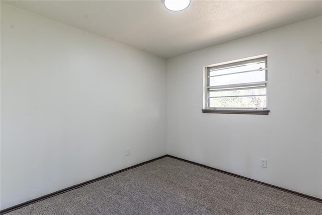 carpeted empty room with baseboards