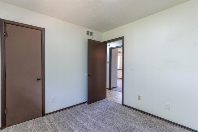 unfurnished bedroom featuring carpet flooring and visible vents