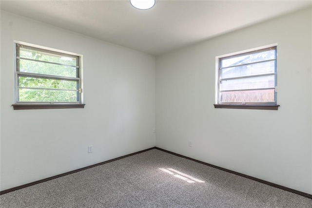 carpeted empty room featuring baseboards