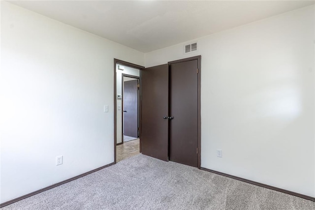 unfurnished bedroom with visible vents and light carpet