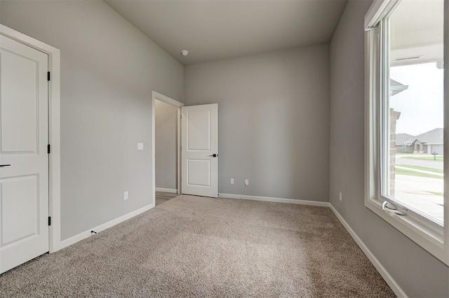unfurnished bedroom with carpet flooring and baseboards
