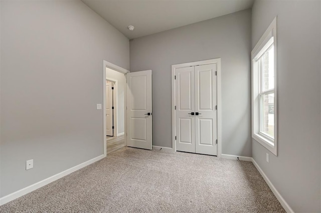 unfurnished bedroom featuring light colored carpet and baseboards
