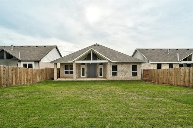 rear view of house featuring a patio area, brick siding, and roof with shingles