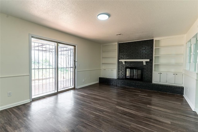 unfurnished living room with built in shelves, a textured ceiling, and dark wood-type flooring