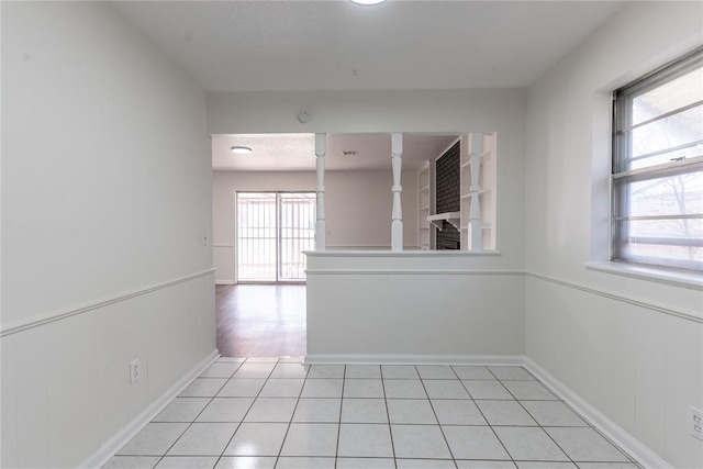 empty room featuring baseboards and light tile patterned floors