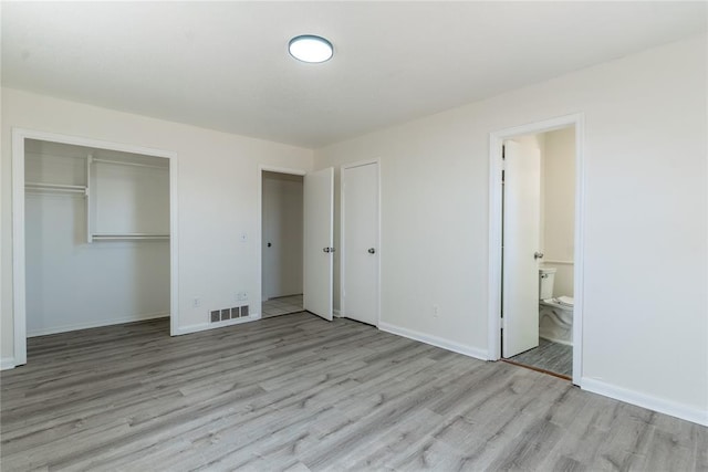 unfurnished bedroom with visible vents, light wood-style floors, and baseboards