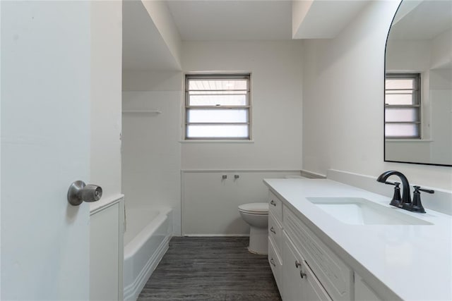 bathroom with vanity, toilet, a tub, wood finished floors, and a shower