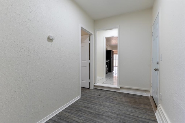 hall with baseboards and dark wood finished floors
