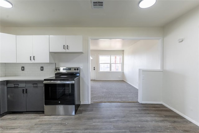 kitchen with visible vents, electric stove, baseboards, and white cabinetry