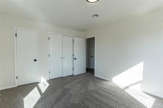unfurnished bedroom with visible vents, carpet flooring, and baseboards