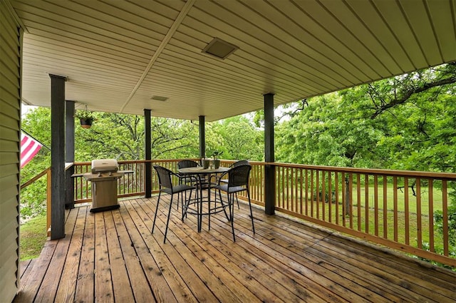 wooden terrace with area for grilling and outdoor dining area