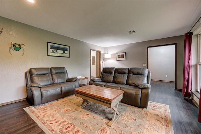 living room featuring baseboards, wood finished floors, and visible vents