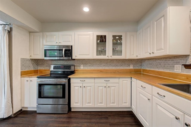 kitchen with white cabinets, appliances with stainless steel finishes, and glass insert cabinets