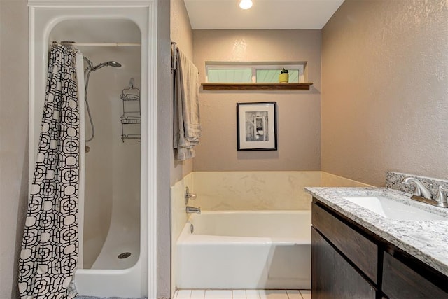 full bath with vanity, a textured wall, a shower stall, and a garden tub