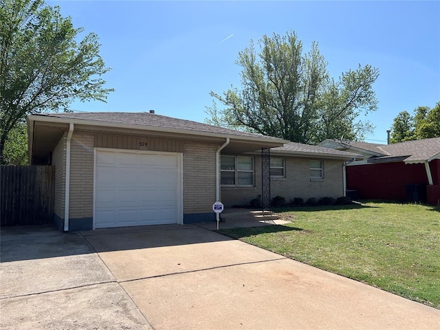 924 N Bradley Ave, Oklahoma City, OK 73127 - ranch-style home with fence, a front yard, brick siding, concrete driveway, and an attached garage