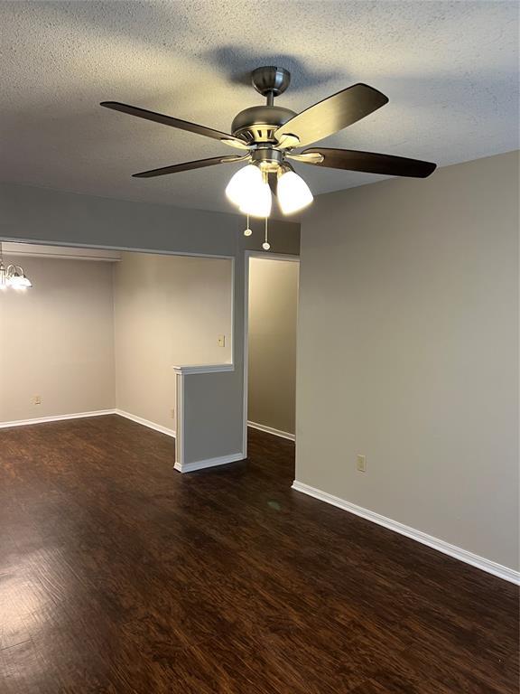 924 N Bradley Ave, Oklahoma City, OK 73127 - unfurnished room with baseboards, a textured ceiling, ceiling fan, and wood finished floors