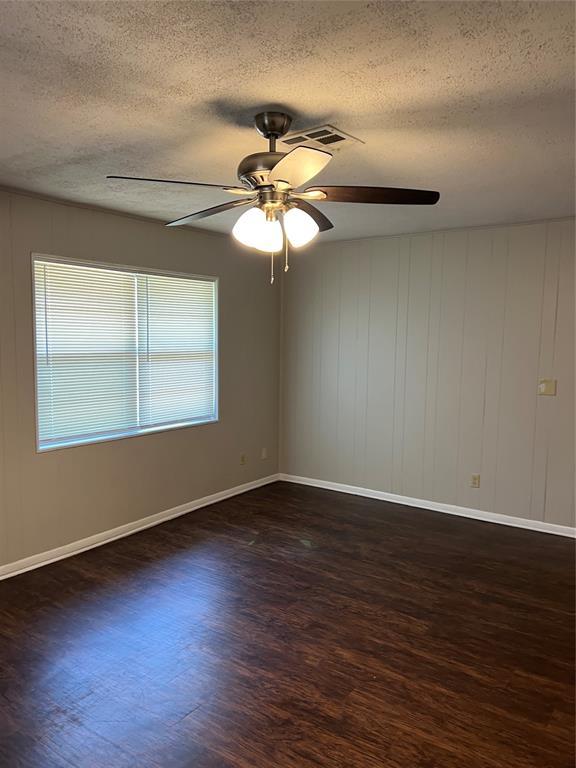 924 N Bradley Ave, Oklahoma City, OK 73127 - empty room featuring a ceiling fan, a textured ceiling, visible vents, wood finished floors, and baseboards