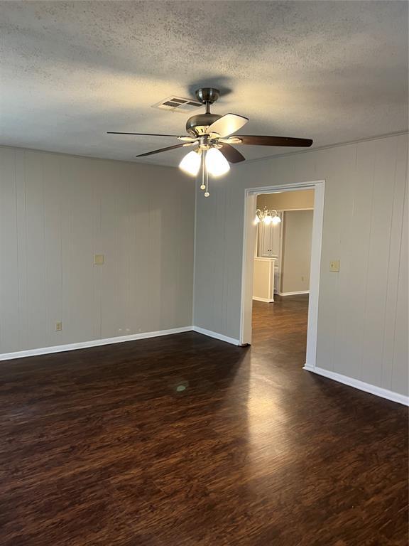 924 N Bradley Ave, Oklahoma City, OK 73127 - empty room with a textured ceiling, baseboards, a ceiling fan, and wood finished floors