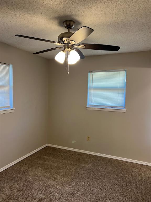 924 N Bradley Ave, Oklahoma City, OK 73127 - carpeted spare room featuring baseboards, a textured ceiling, and ceiling fan