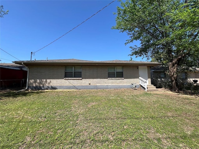 924 N Bradley Ave, Oklahoma City, OK 73127 - rear view of property featuring brick siding, a lawn, and entry steps