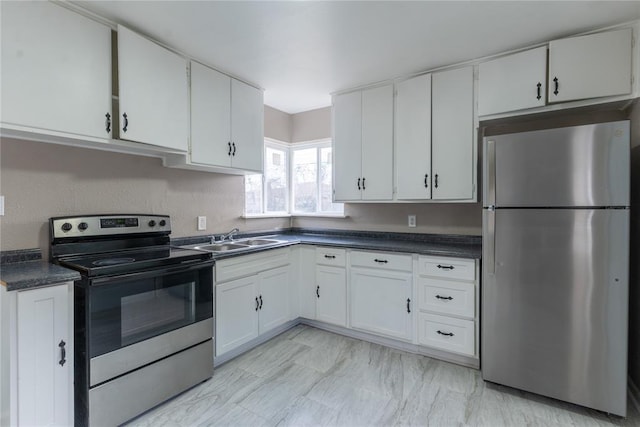 kitchen with a sink, dark countertops, white cabinets, and stainless steel appliances