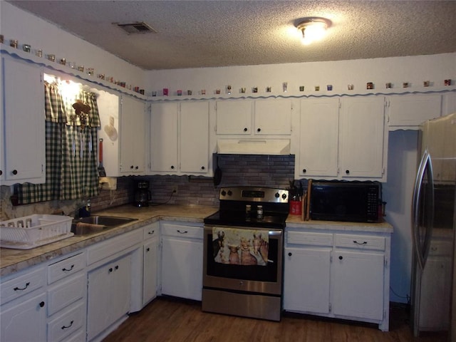 kitchen with stainless steel electric range, black microwave, freestanding refrigerator, white cabinetry, and under cabinet range hood