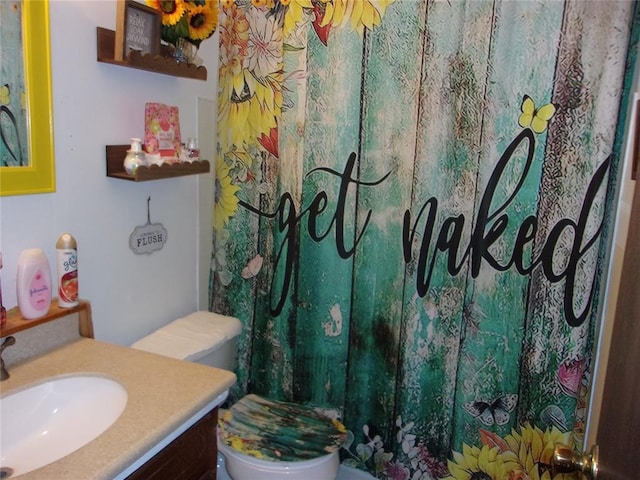 bathroom with toilet, a shower with shower curtain, and vanity