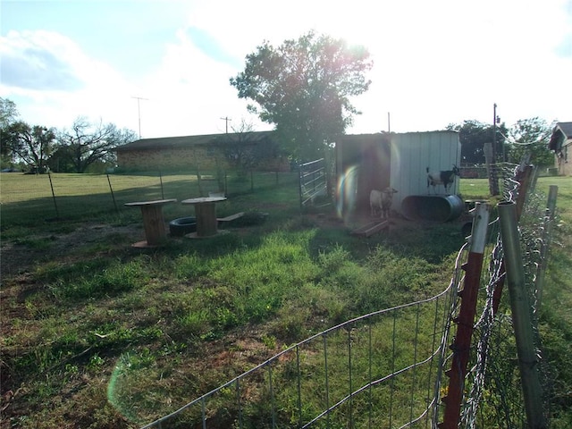 view of yard with fence and an outdoor structure