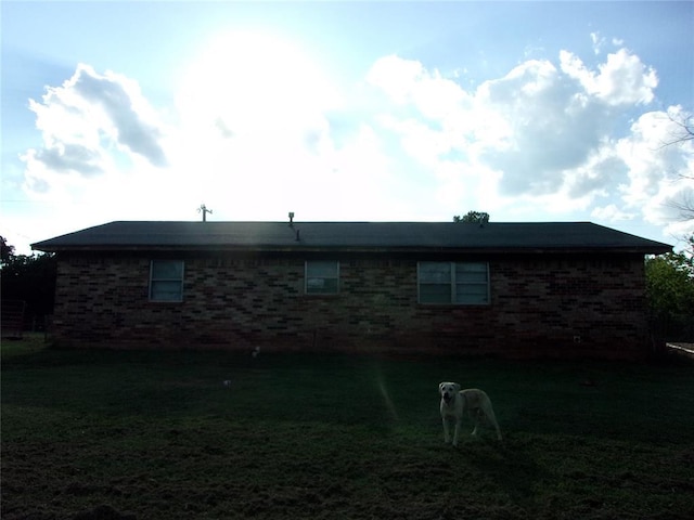 view of property exterior with a lawn and brick siding