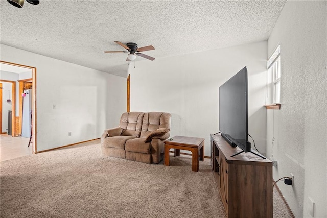 carpeted living room with baseboards, a ceiling fan, and a textured ceiling