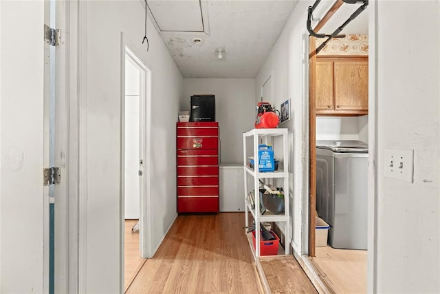 washroom with cabinet space, washer / dryer, and light wood-style floors