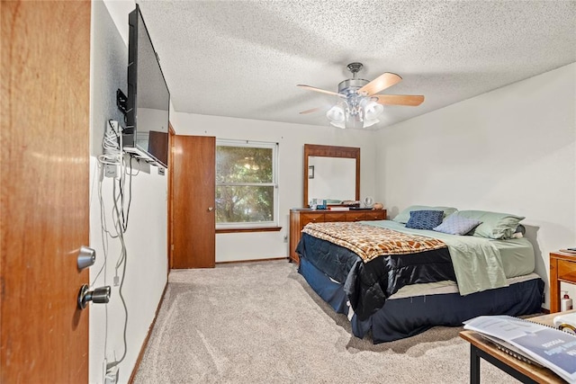 carpeted bedroom with baseboards, ceiling fan, and a textured ceiling