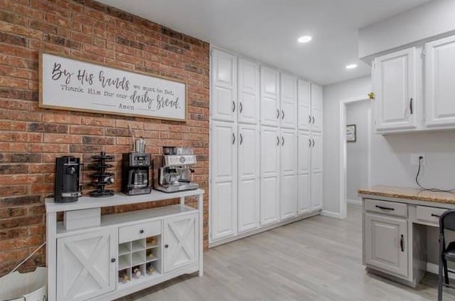 bar featuring recessed lighting, light wood finished floors, baseboards, and brick wall