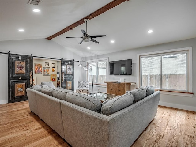 living room featuring ceiling fan, lofted ceiling with beams, a barn door, light wood finished floors, and recessed lighting