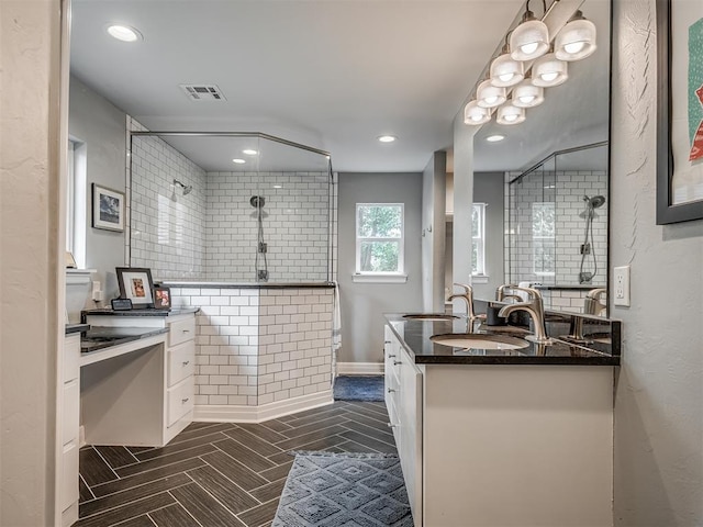 full bath featuring vanity, recessed lighting, visible vents, and tiled shower