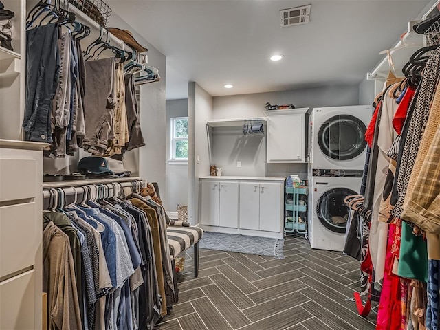 clothes washing area featuring cabinet space, recessed lighting, visible vents, and stacked washer / dryer