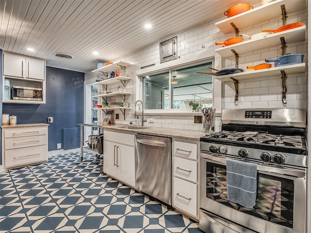 kitchen with open shelves, light floors, white cabinets, a sink, and stainless steel appliances