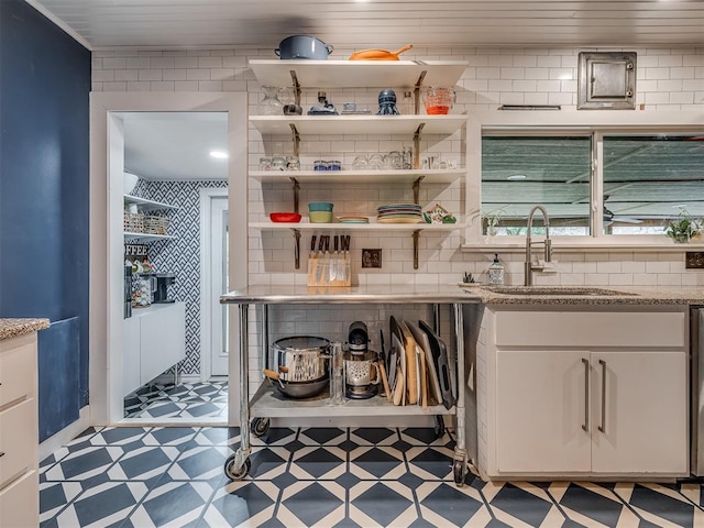 bar featuring a sink, light floors, and decorative backsplash