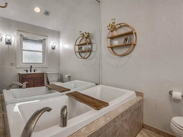 full bathroom featuring a relaxing tiled tub, toilet, baseboards, lofted ceiling, and visible vents