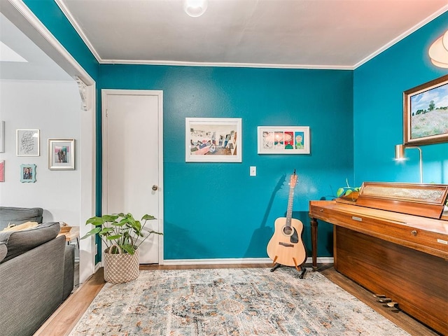 interior space with crown molding, baseboards, and wood finished floors