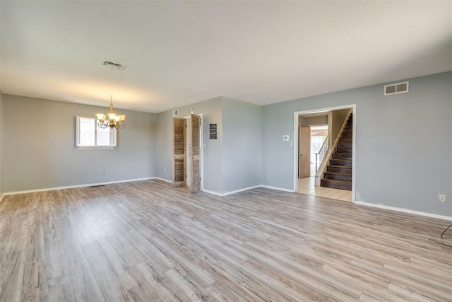 unfurnished room featuring visible vents, stairs, baseboards, and a notable chandelier