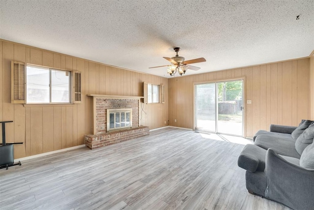 living room with baseboards, a ceiling fan, a textured ceiling, and wood finished floors