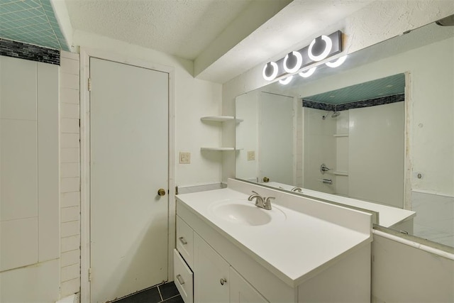 bathroom featuring vanity, a textured ceiling, and a shower