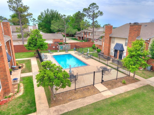 pool with a patio area, fence, and a residential view