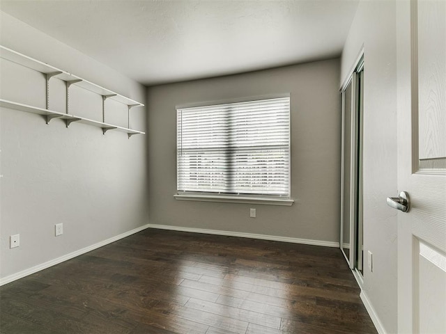 unfurnished bedroom featuring baseboards, a closet, and wood finished floors
